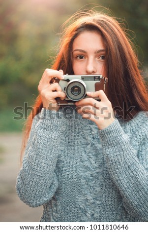 A young woman is taking pictures outdoors