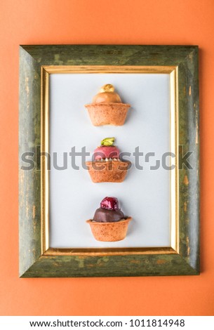 Dessert - cake tarts with fruits and berries in the frame of the picture on an orange background. Fresh delicious food.