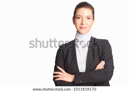 A smiling middle aged businesswoman wearing suit while standing with arms crossed and looking at camera at isolated white background.