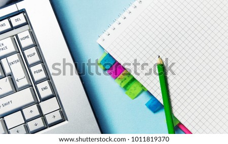 notepad with bookmarks, pencil for recording and laptop. Office theme.