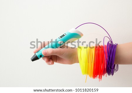 3d handle (pen). Colored plastic in coils. 3d paintings and figures with their own hands. Handmade. STEM education. Play and study at school and at home. New toy for child. Background. Like. Royalty-Free Stock Photo #1011820159