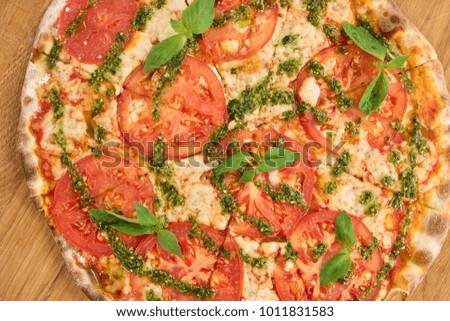 Down view fresh sliced pizza with tomatoes. Cooked pizza with tomatoes and basil, close up.