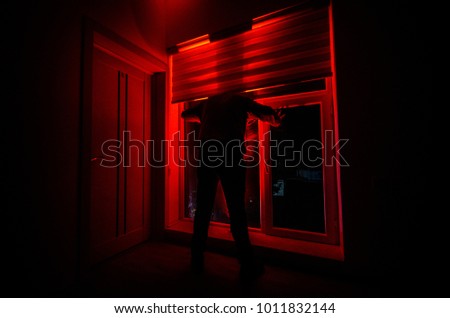 Horror man in window scary scene halloween concept Blurred silhouette of ghost. Horror theme. Selective focus