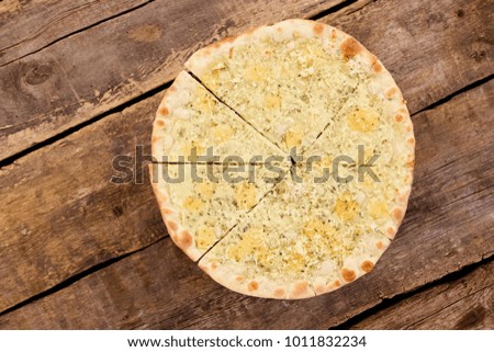 Eight slices of cheese pizza. Cut cheese pizza on wooden table, top down view.