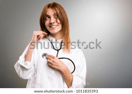Young doctor woman on grey background