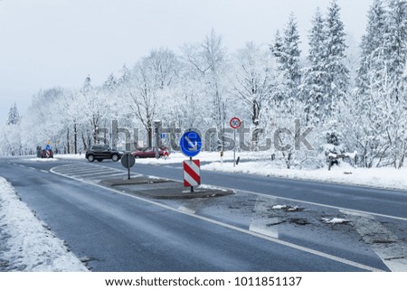 snow-covered intersection with speed limit and radar
