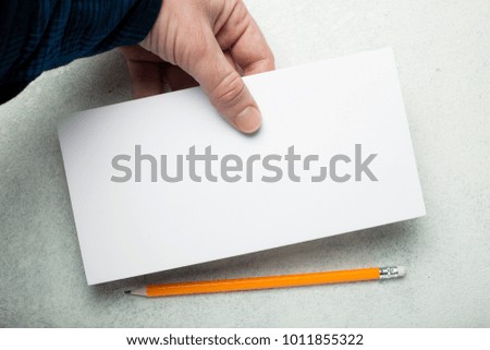 A hand holds a DL flyer on a white vintage background.