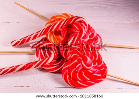 Pile of different sweet lollipops on wooden table