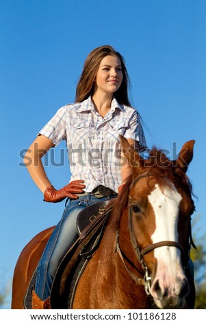 Beautiful girl  riding a horse against blue sky