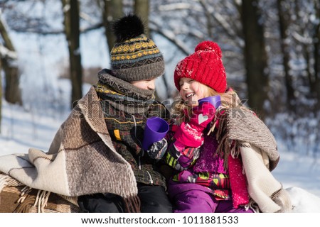 Girl and boy have conversation and drinking hot beverages outdoors
