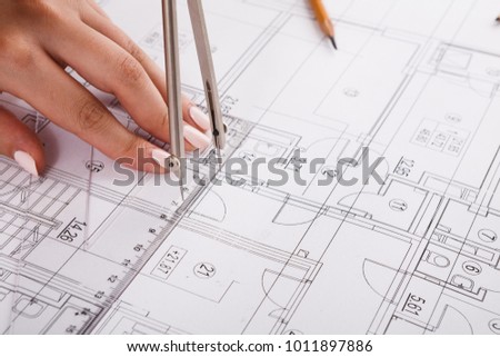 Architect drawing architectural project closeup. Unrecognizable designer hands working with building blueprint, copy space