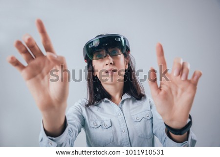 Woman wearing augmented reality goggles. White background in studio