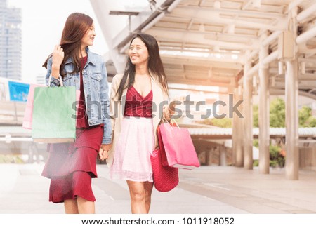 two young women shopping, sale, consumerism and people concept