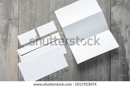 Blank business cards, letterheads and envelopes on wooden desk. Clean 3d illustration to showcase your presentation.