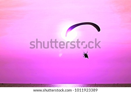 impressive scene on composition of flying paramotor into the air at front of the sun in graphic style so beautiful pattern for background