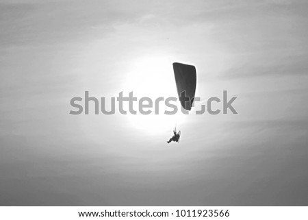 impressive scene on composition of flying paramotor into the air at front of the sun in graphic style so beautiful pattern for background