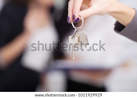 Real estate agent giving house keys to a customer