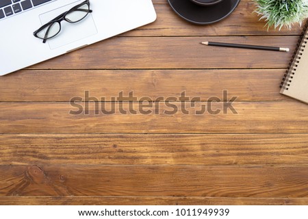 Flat lay of top view desk work table with computer laptop and stationary in home office on antique brown wood table includes copyspace for add text or graphic