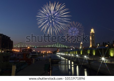 Colorful fireworks explode over bridge. Montreal Clock Tower at night. luminous colorful interactive Jacques Cartier Bridge. Old port montreal. Reflection in water. Montreal’s 375th anniversary. 