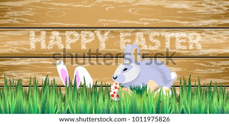 Easter. Rabbit easter in the grass on a background of a wooden fence in Easter eggs. horizontal sheet orientation