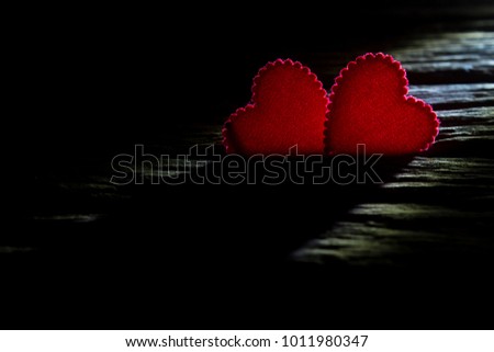 Valentine's day concept two red hearts symbol on wood floor,copy space for text,light and shadow style.