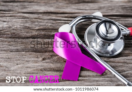 Purple ribbon awareness and stethoscope on wooden background  for World Cancer day campaign.