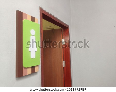 Female restroom sign on wall beside door