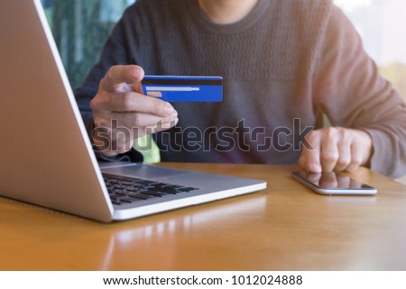 Man holding credit card and typing mobile with shopping online. Royalty-Free Stock Photo #1012024888