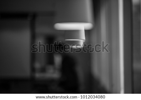 A hanging lamp in white, black and white photography.