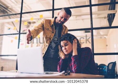 Female student feeling upset with project failure listening to coach critics during meeting in office, irritated leader of company checking work of employee angry about bad ideas and accountings Royalty-Free Stock Photo #1012045378
