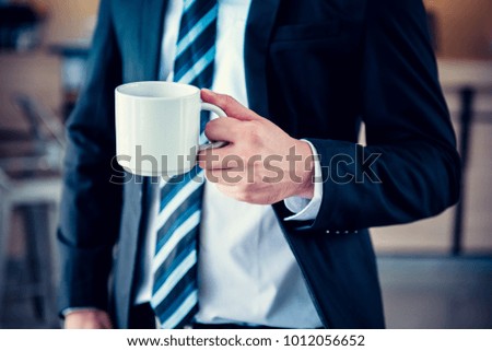 Businessman with coffee, smart standing in the office