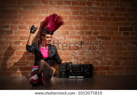 Young punk girl on brick wall background