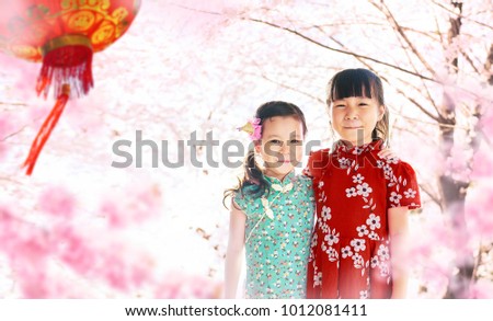 Two adorable girl wearing cheongsam during chinese new year season .
