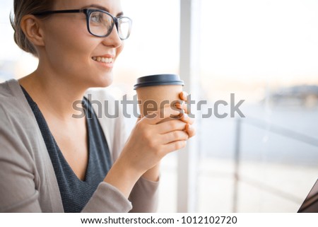 young smiling caucasian woman with glasses holds in her hands coffee 