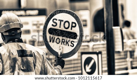 Roadworks signal with worker standing.
