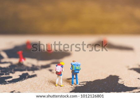 Miniature people travelers walking on world map , Traveling and exploring the world Concept