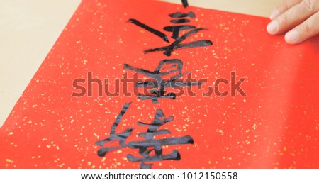 Writing Chinese calligraphy on write paper with phrase meaning happy new year 