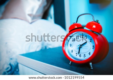 Retro alarm clock on wooden bed side table 