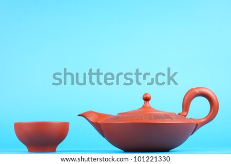 Arabian old ceramic brown teapot with teacups isolated on blue