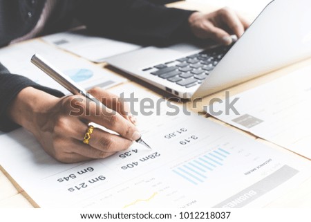 Business women reviewing data in financial charts and graphs