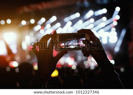 Hands with a smartphone records live music festival, Taking photo of concert stage, live concert