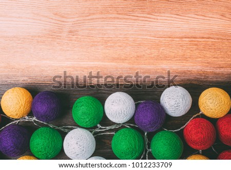 Colored garlands on a color wooden background. Place for text or logo.
