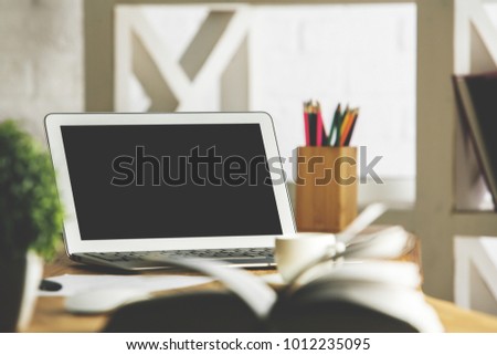 Close up of creative designer desktop with blank laptop screen, coffee cup, supplies and other items. Workplace concept. Mock up 