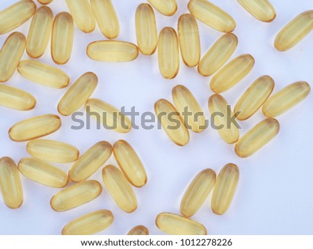 Top view fish oil capsules on white wooden background .