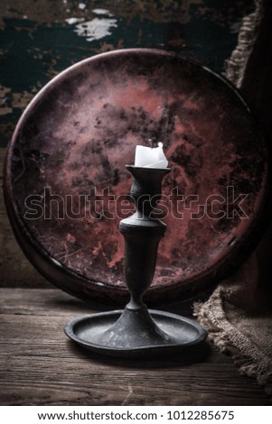 Old candle on a wooden background. Toned.