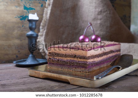 Homemade cherry cake with chocolate decor on a rustic style background. Selective focus.