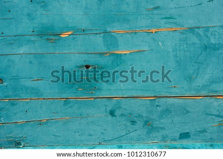Close-up - wooden boards painted in old blue peeling paint. Background wallpapers