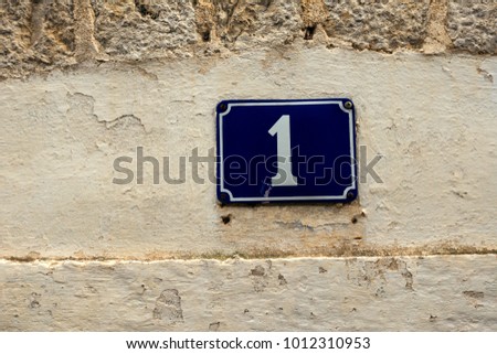 Close-up - the number one on the blue street sign on the front of the house. Background image. Conceptual wallpaper