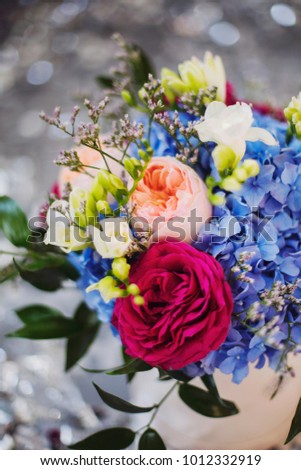 Flower bouquet composition with blue hydrangea, ranunculus and peonies on bokeh background