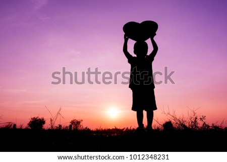 Silhouette a boy with heart shape at sky sunset.Concepts of Love and Valentine's Day